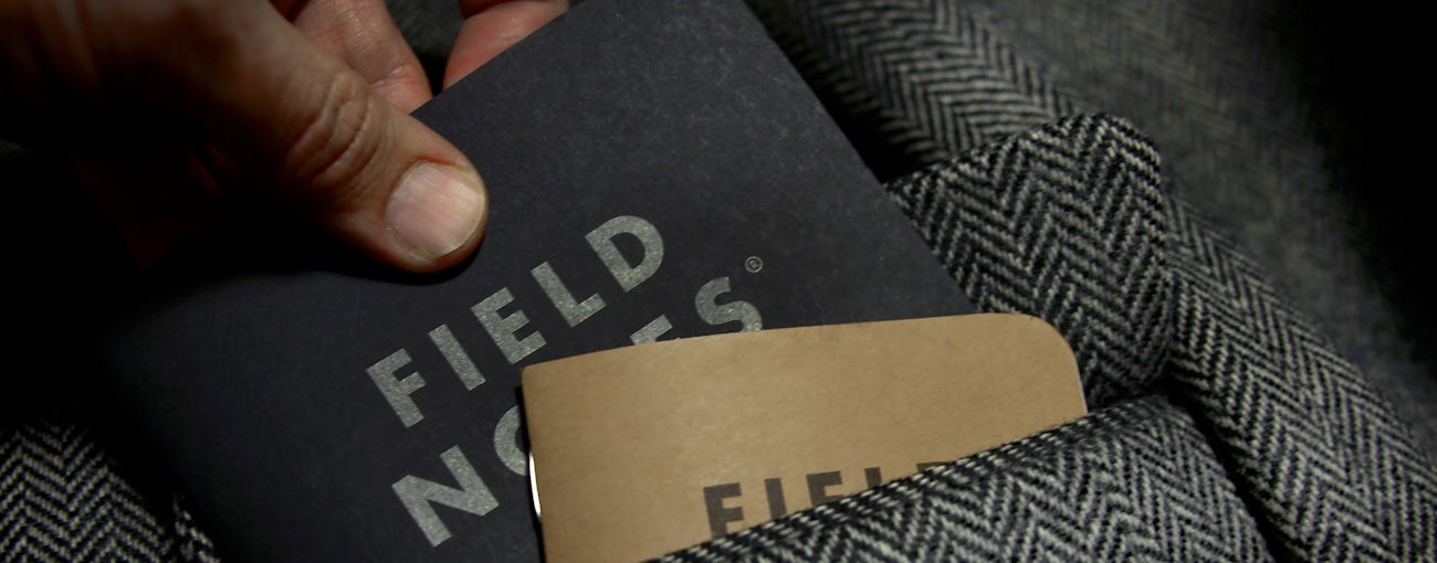 Close-up of the Pitch Black notebook being pulled from a coat pocket.